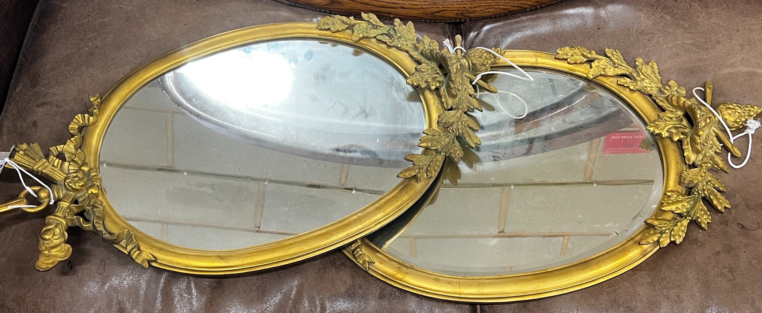 A pair of oval brass framed wall mirrors, width 36cm, height 71cm